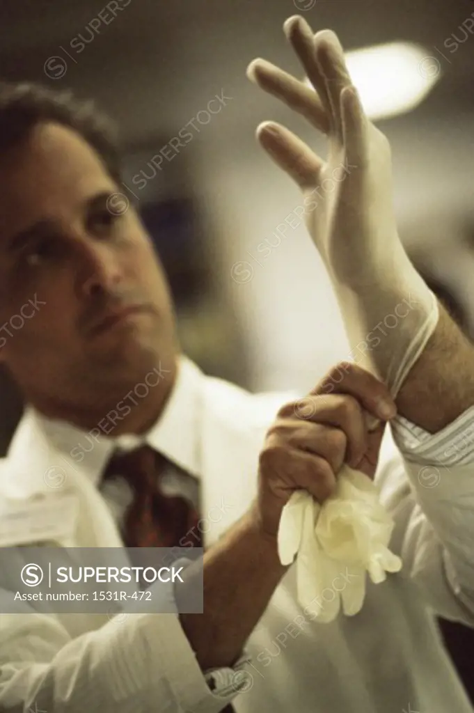 Male surgeon putting on surgical gloves