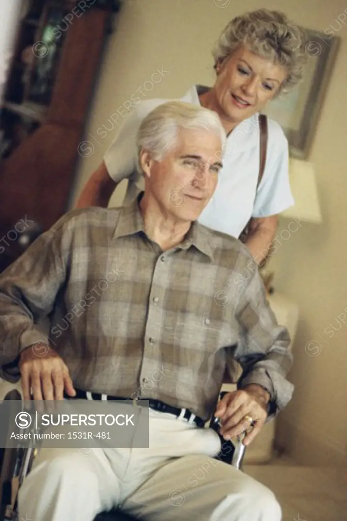Senior woman pushing a senior man in a wheelchair