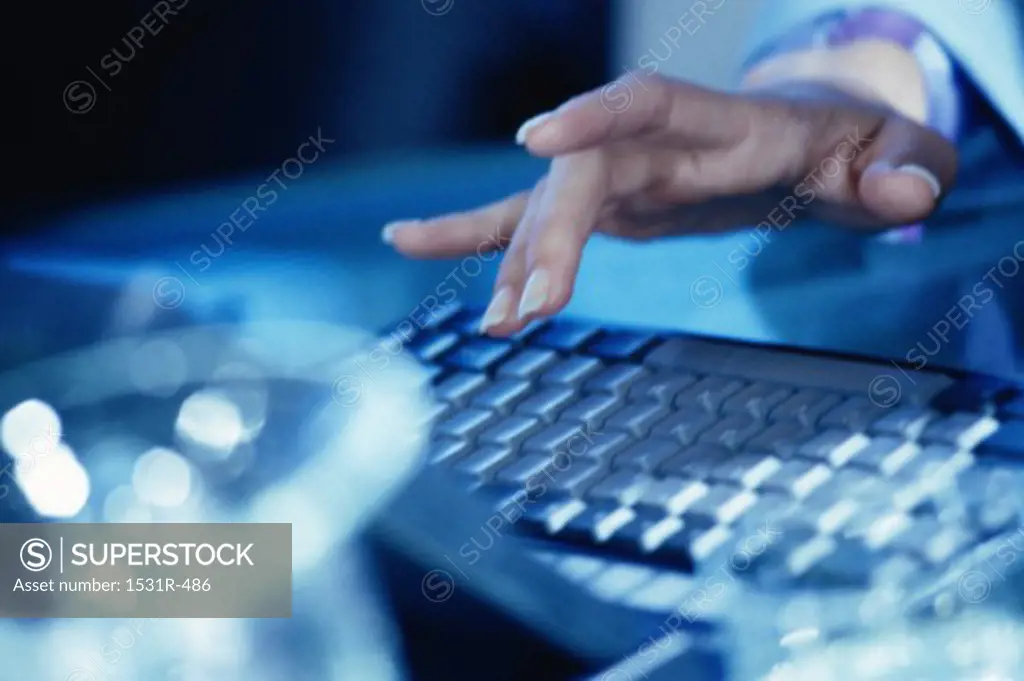Close-up of a person's hand operating a laptop