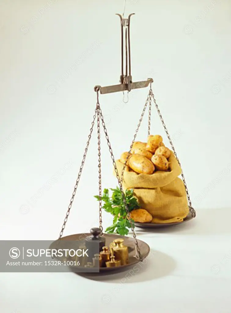 Hanging scales with weights and sack of potatoes