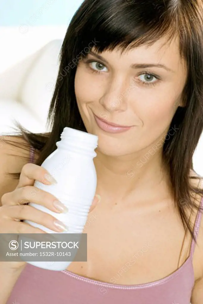 Young woman with a bottle of drinking yoghurt