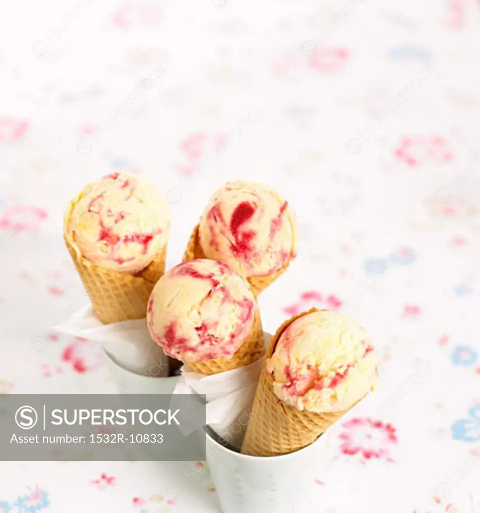 Scoops of vanilla and raspberry ice cream in cones