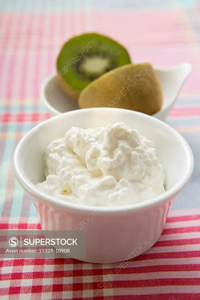 Cottage cheese in a small bowl, kiwi fruit behind