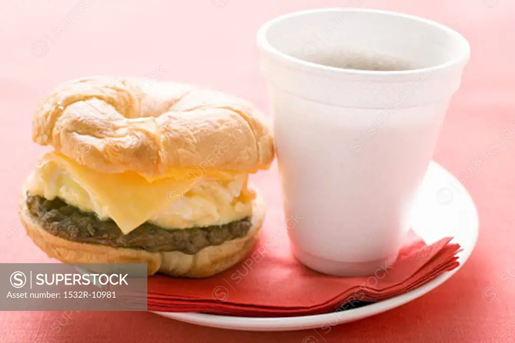 Cheeseburger with scrambled egg and a cup of coffee