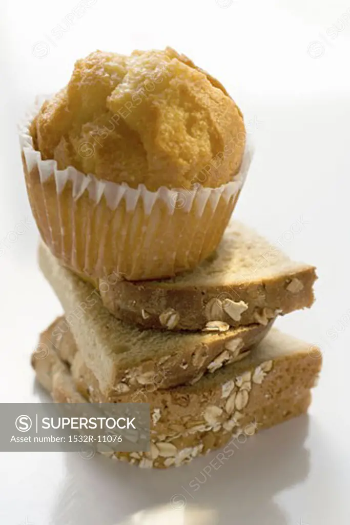 Slices of bread in a pile with a muffin on top