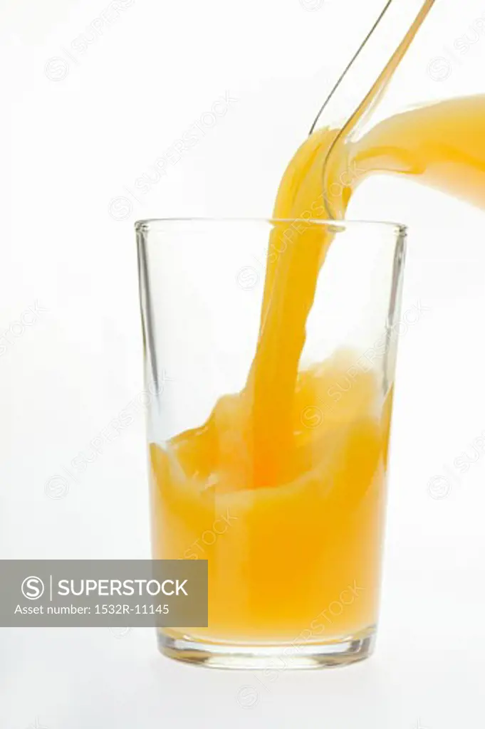 Pouring orange juice into juice glass (2)