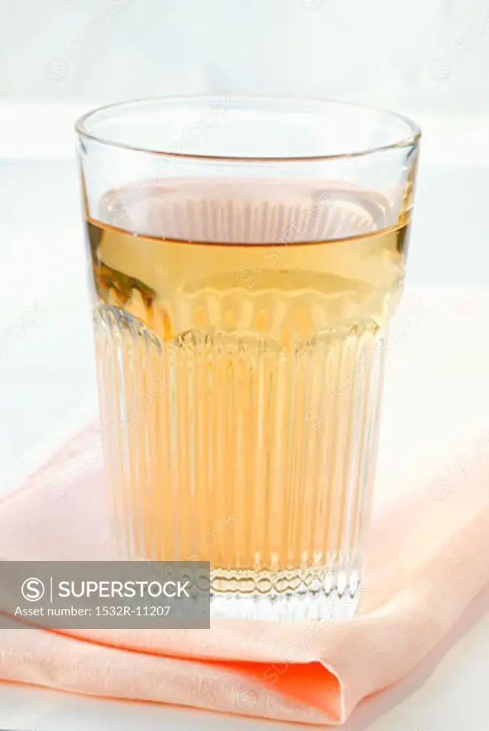 Apple juice in glass on fabric napkin