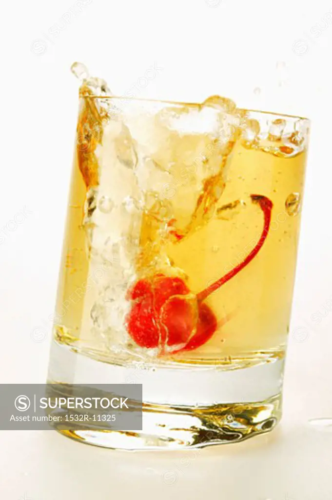 Ginger Ale with cocktail cherry splashing out of glass (1)