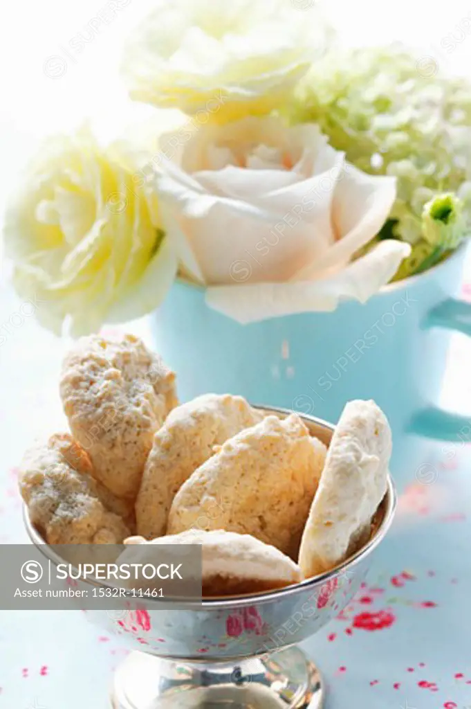 Almond macaroons in front of bouquet of flowers