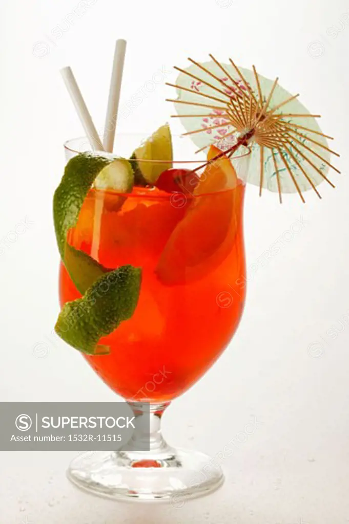 Cocktail with fruit, lime zest and cocktail umbrella