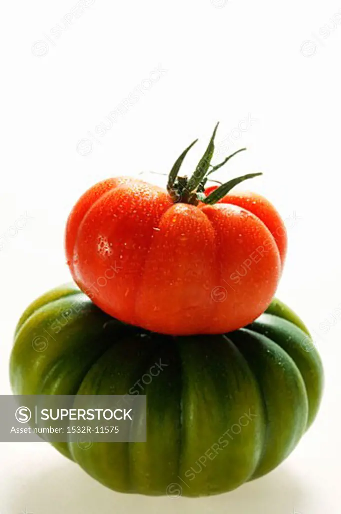 Green and red beefsteak tomato with drops of water