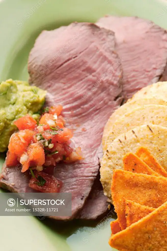 Roast beef with tomato salsa, guacamole and tortilla chips