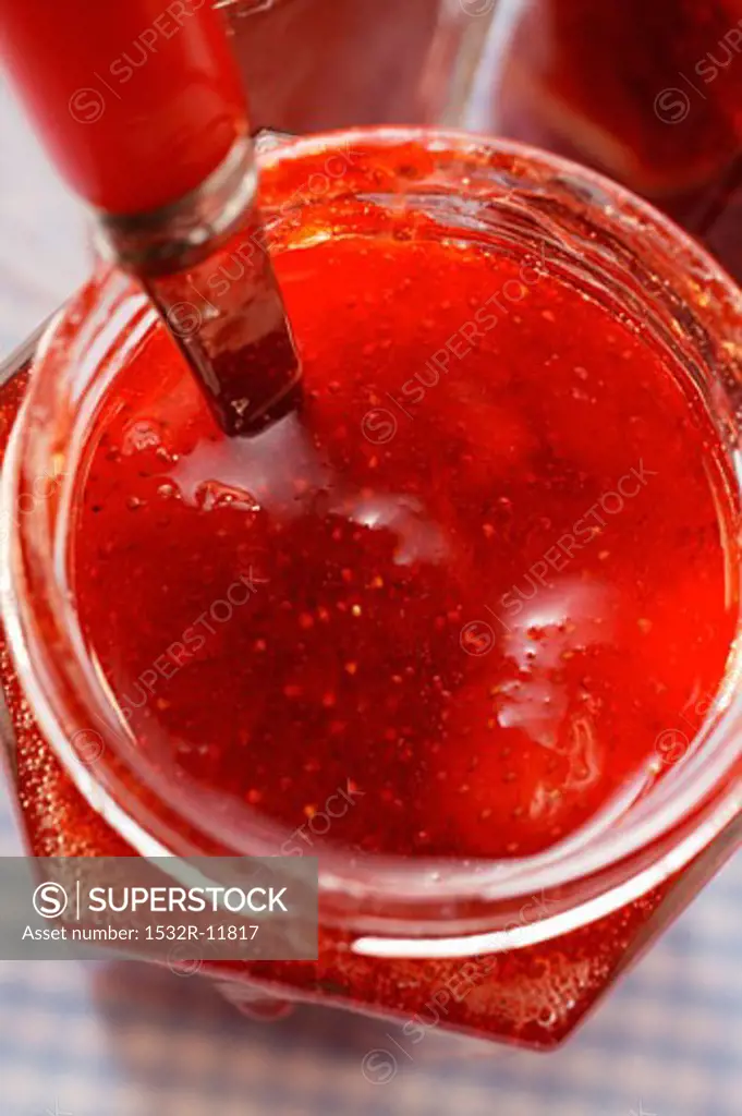 Strawberry jam in jar with spoon