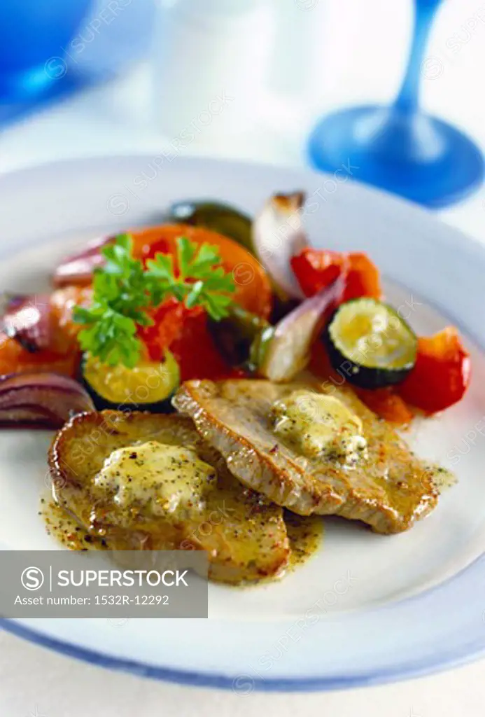 Pork steaks with herb butter and vegetable accompaniments