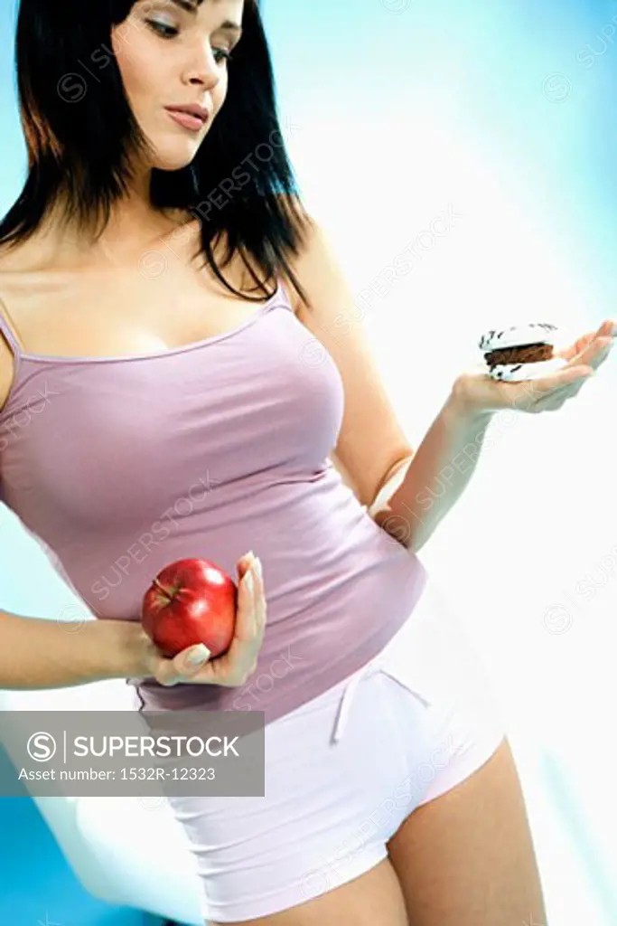 Young woman with biscuit and apple in her hand