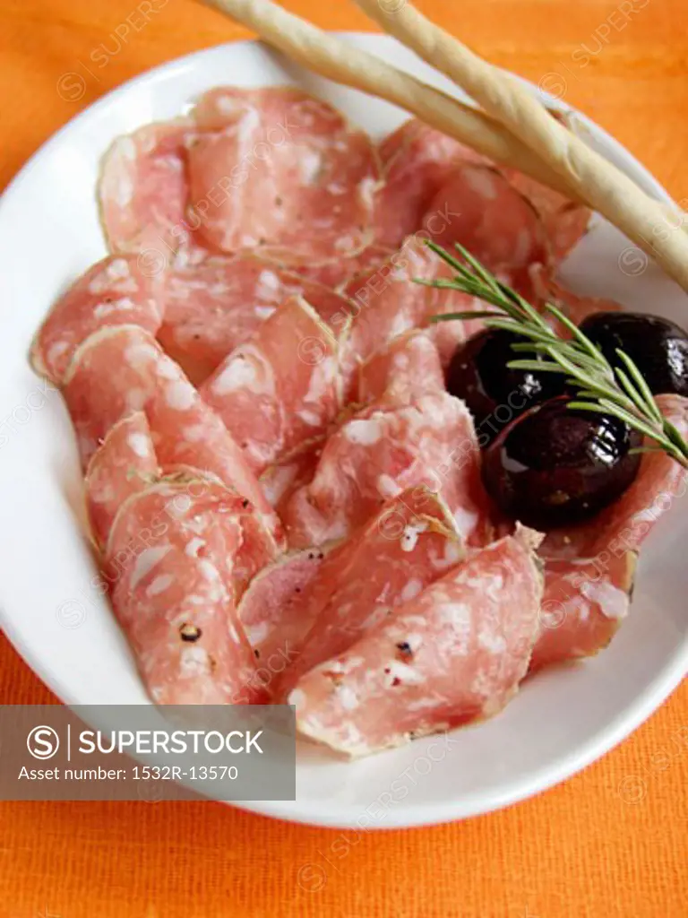 Sliced Salami with Bread Sticks and Olives