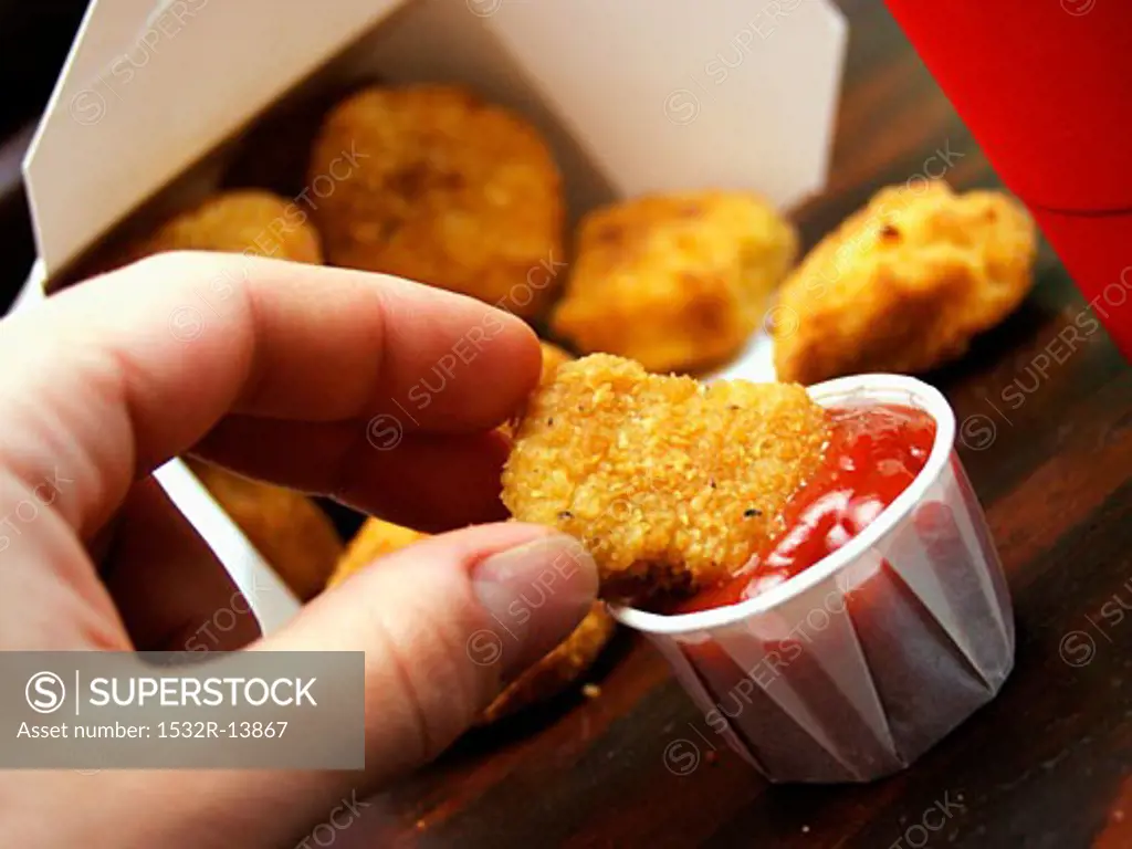 Dipping Chicken Nugget into Ketchup
