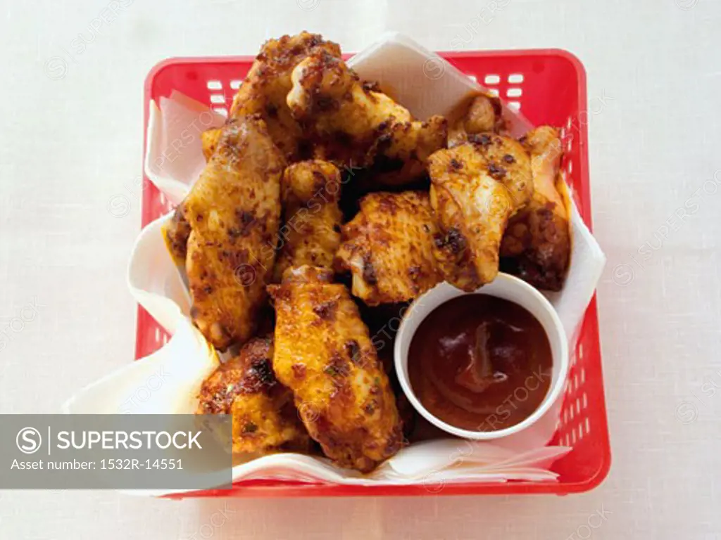 Barbecued chicken wings in plastic basket