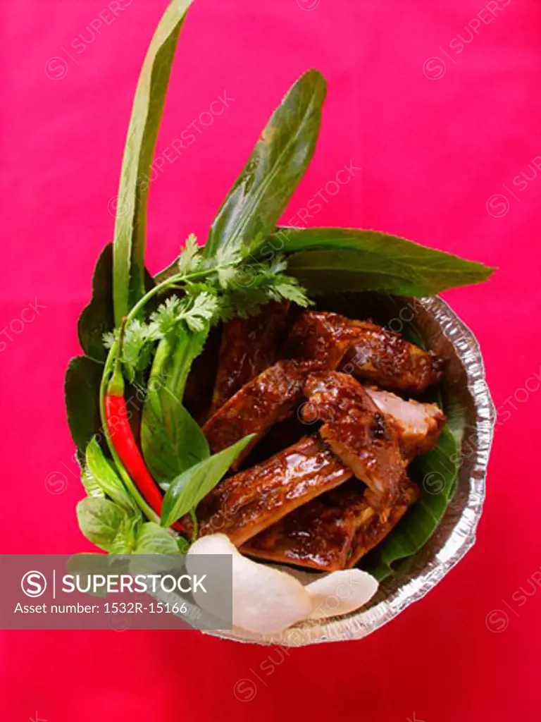 Crispy spare-ribs with herbs and krupuk in aluminium dish