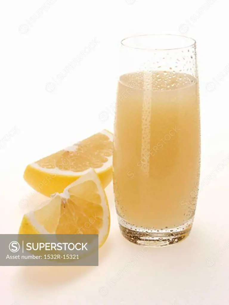 Grapefruit juice in glass beside grapefruit wedges