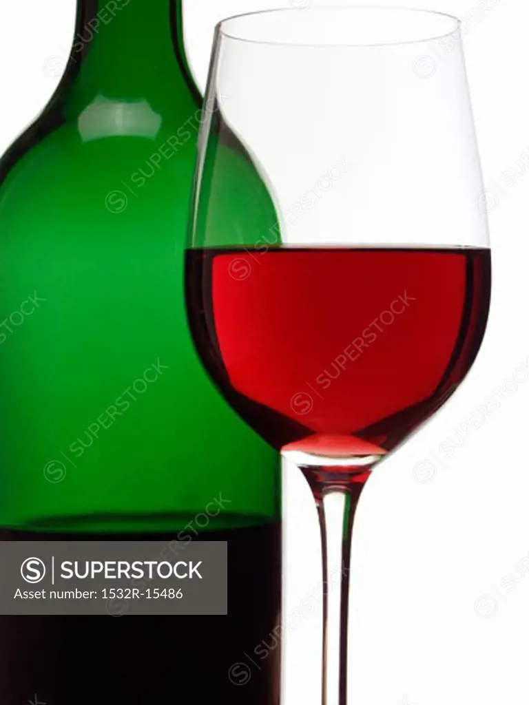 Red wine glass in front of red wine bottle