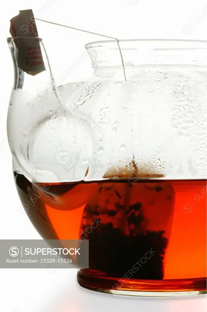 Fruit tea in glass teapot with tea bag