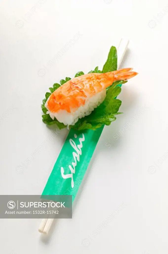 Nigiri sushi with shrimp on shiso leaf, chopsticks
