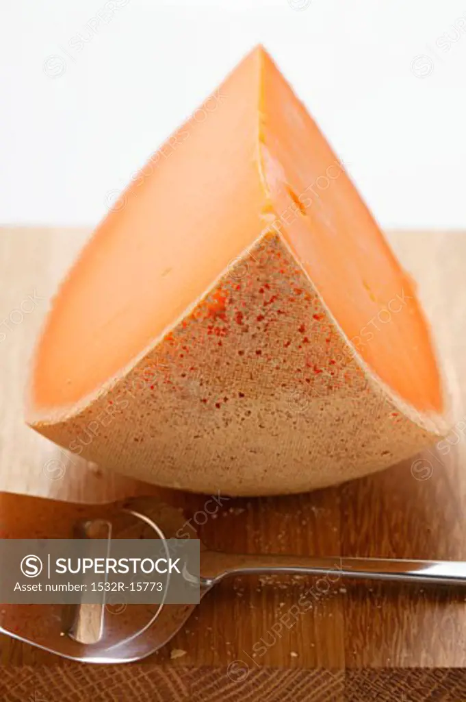 Cheddar with cheese slicer on chopping board
