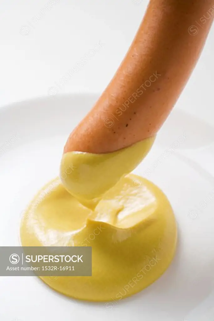Dipping a sausage in mustard