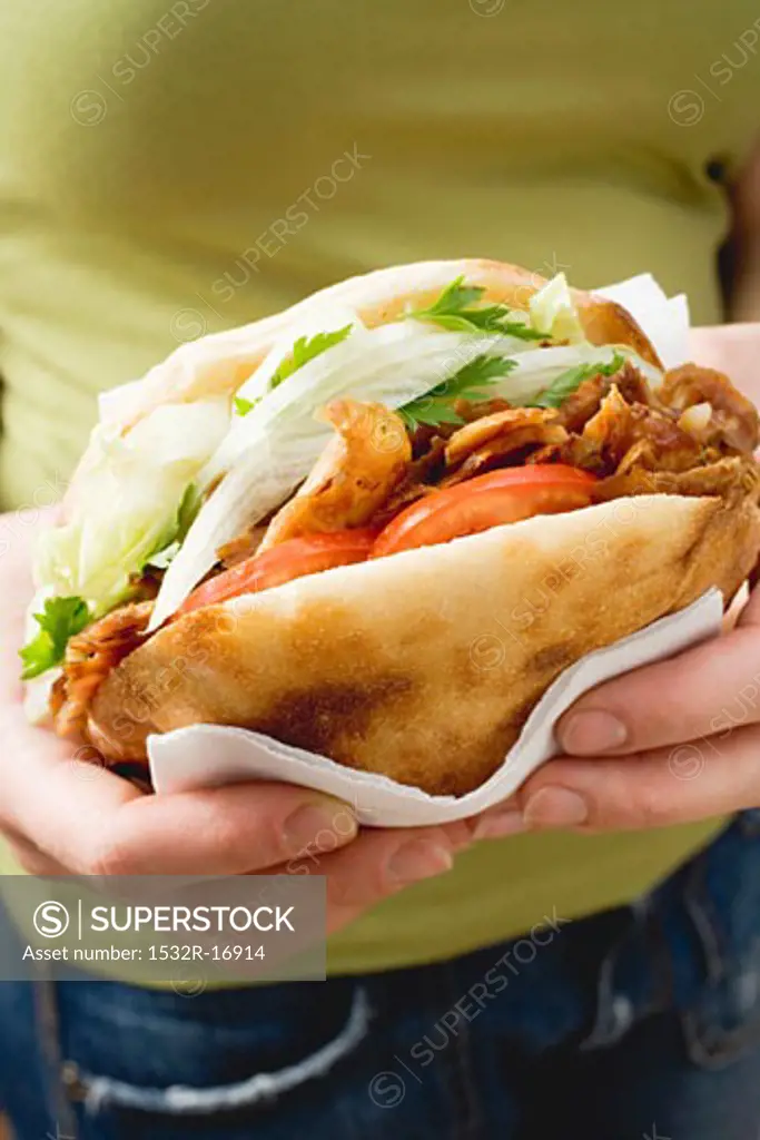 Hands holding a döner kebab