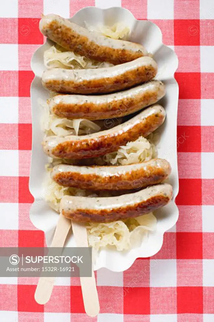 Sausages with sauerkraut on paper plate