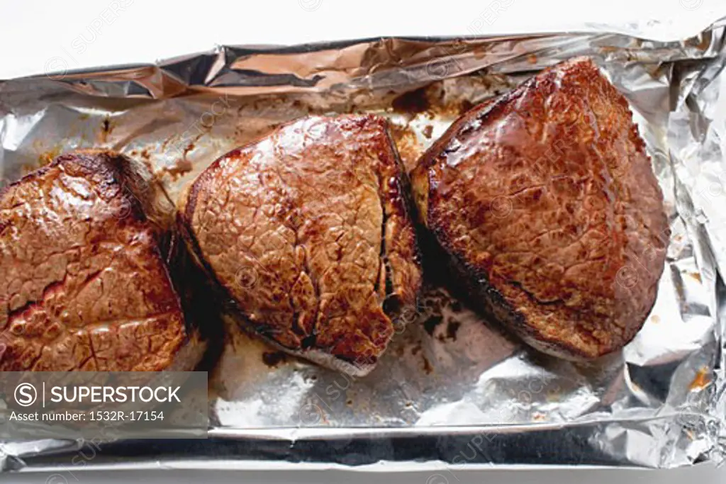 Three fillet steaks on aluminium foil
