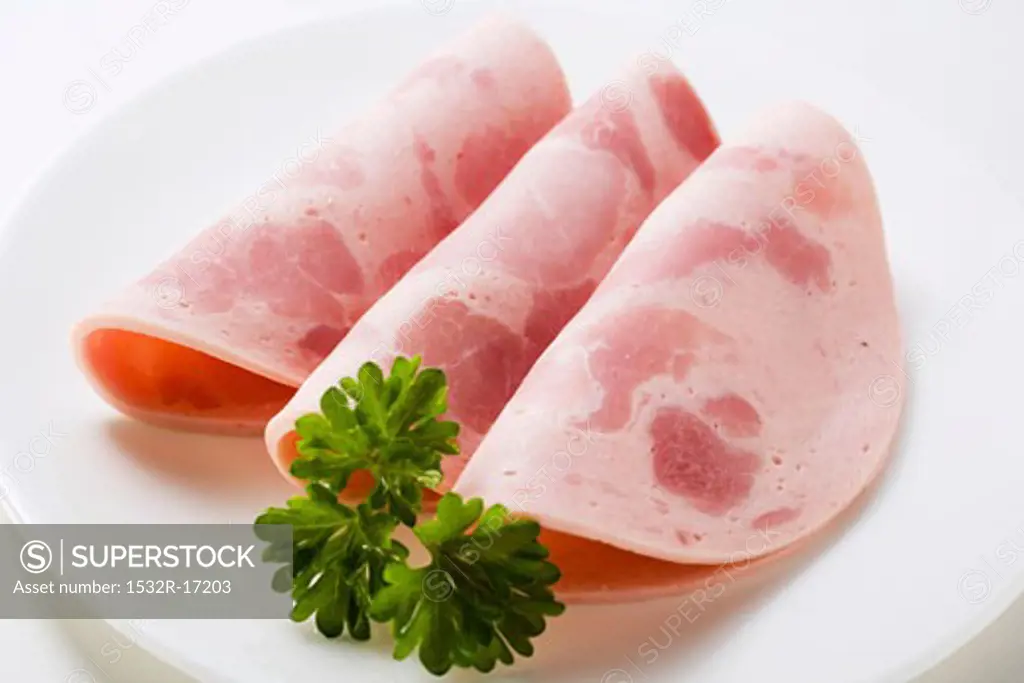 Three slices of Bierschinken (ham sausage) with parsley