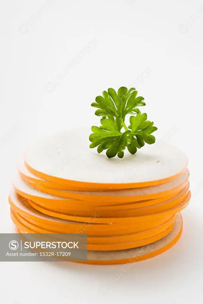 Slices of Gelbwurst (pork & veal sausage) in a pile with parsley