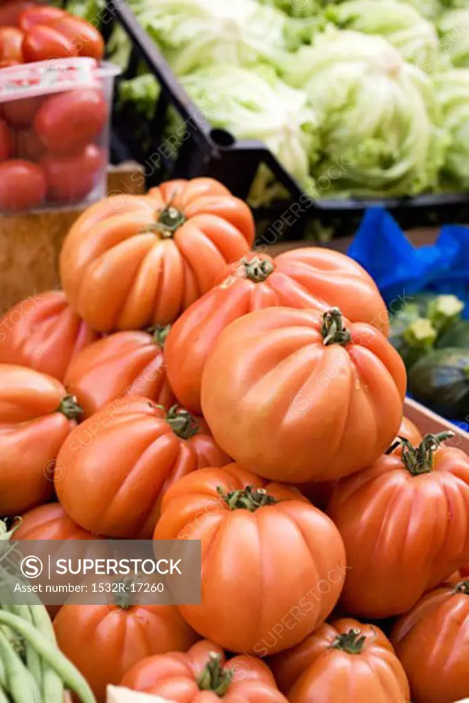 Large beefsteak tomatoes in a crate at a market