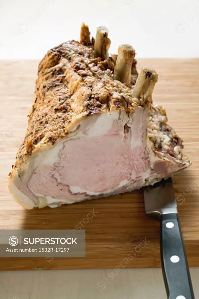 Rack of pork on chopping board with knife