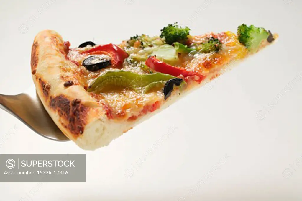 Slice of American-style vegetable pizza on server