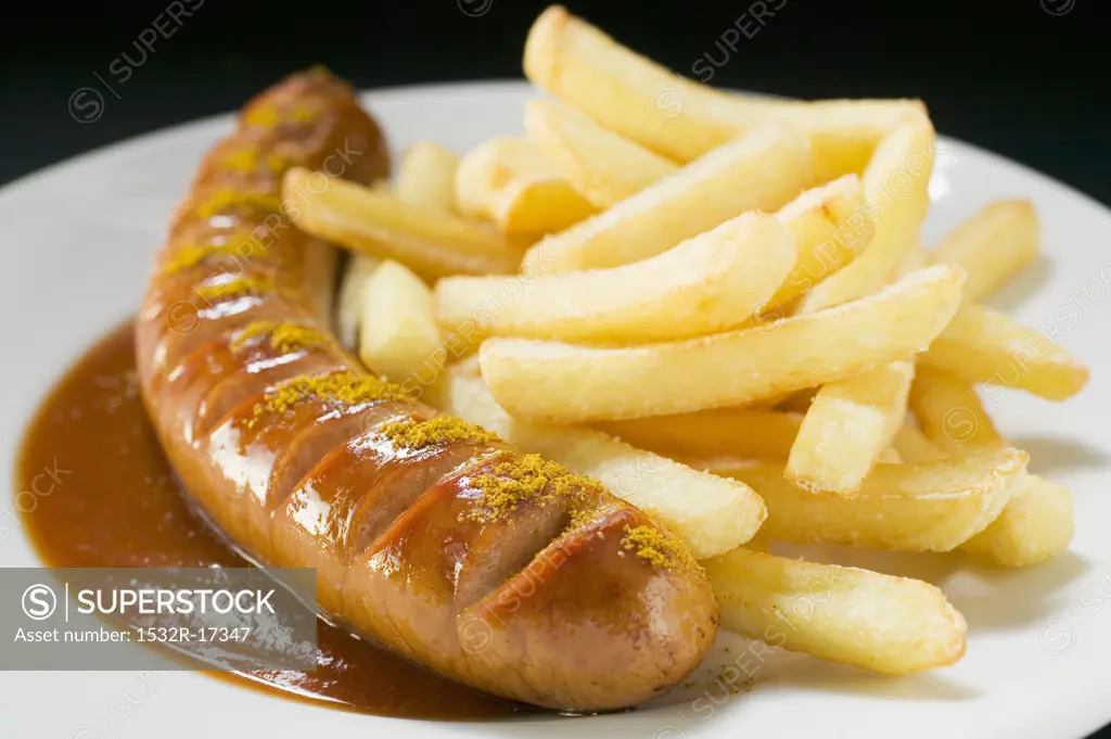 Currywurst (sausage with ketchup & curry powder) & chips on plate