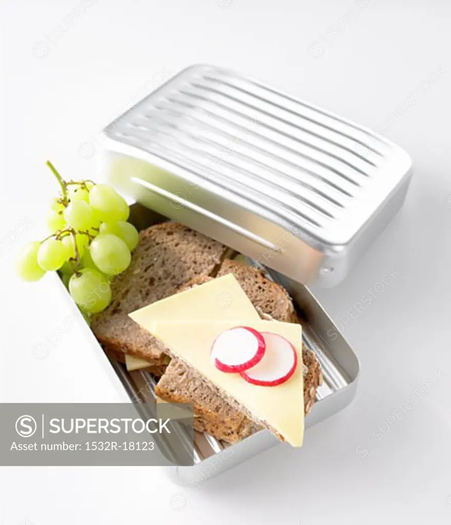 Cheese sandwiches and green grapes in lunch box
