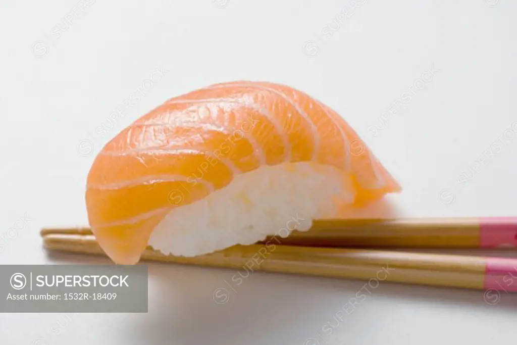 Nigiri sushi with salmon on chopsticks