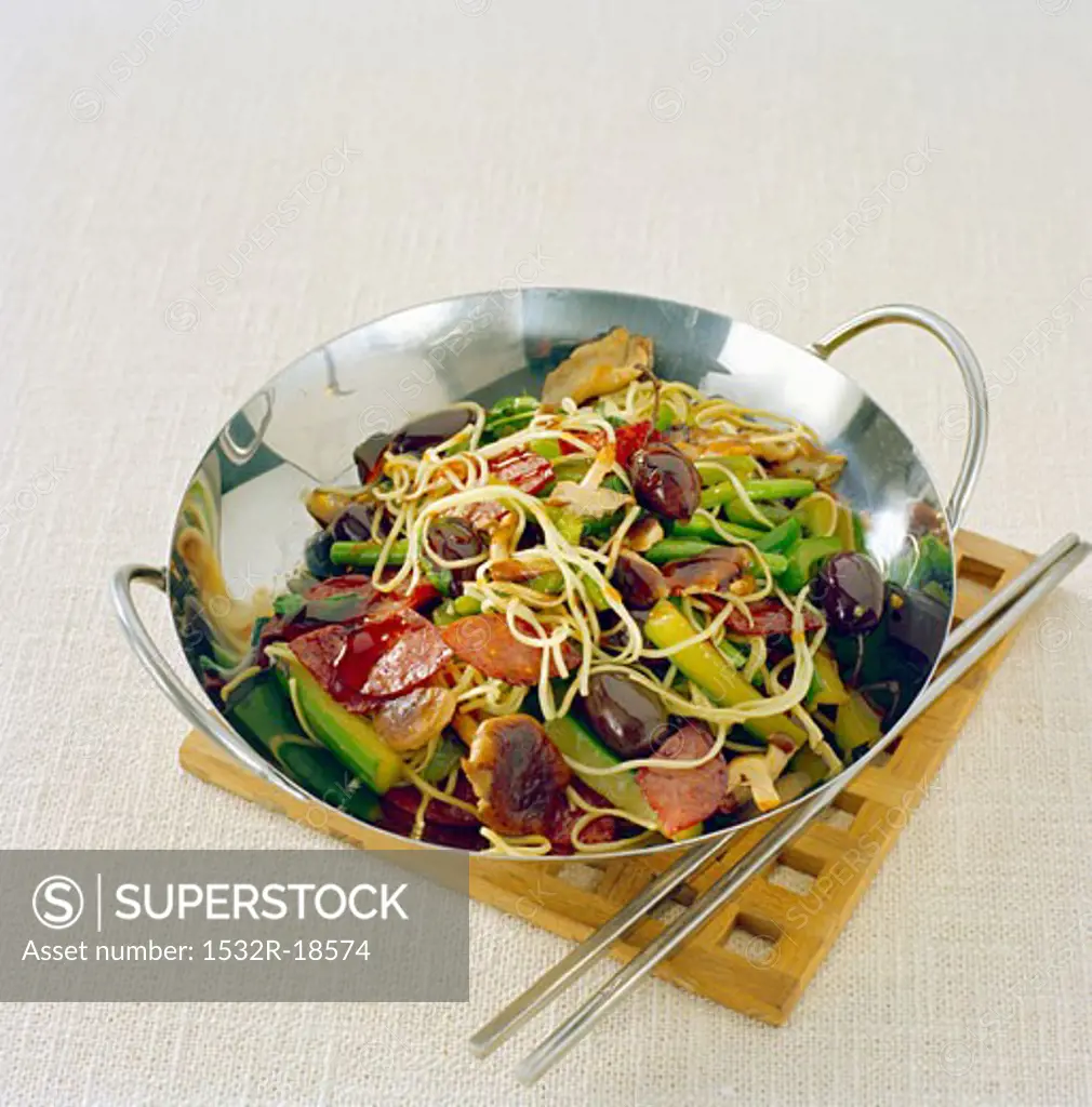 Sausages, noodles and vegetables cooked in wok
