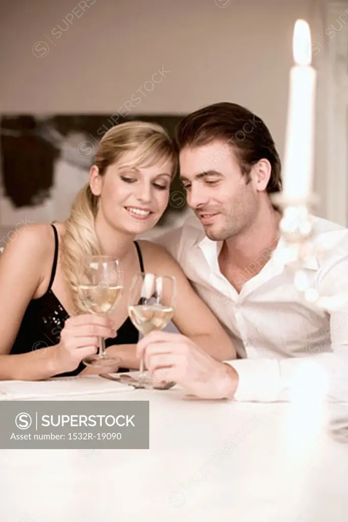 Young couple clinking white wine glasses