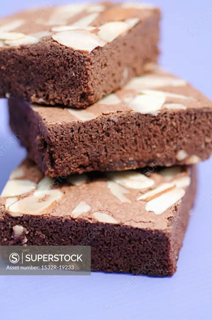 Three brownies with almonds in a pile