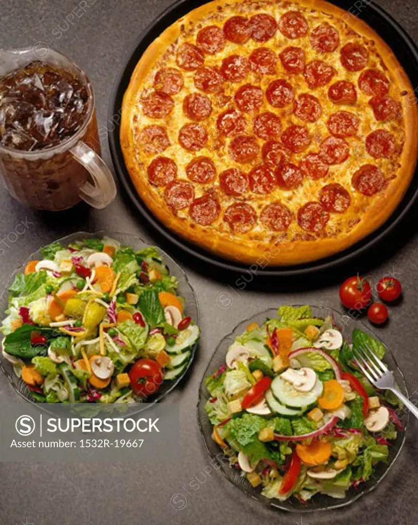 A Pepperoni Pizza with Two Salads and a Pitcher of Soda