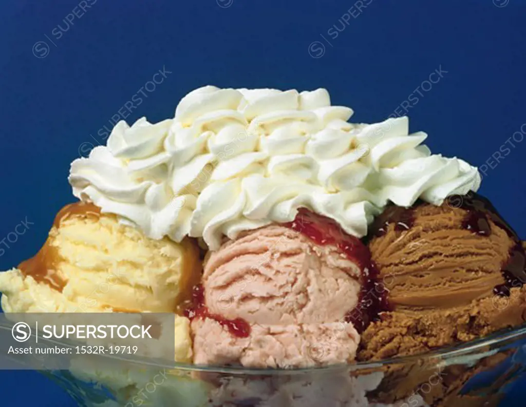 Three scoops of ice cream with various sauces and cream