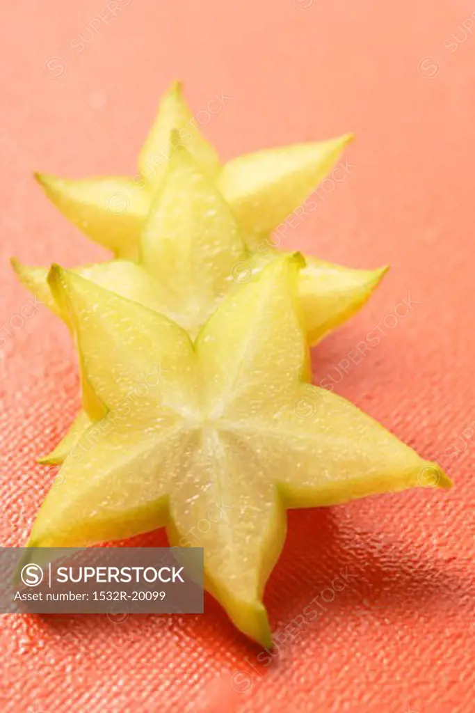 Three slices of carambola on red background