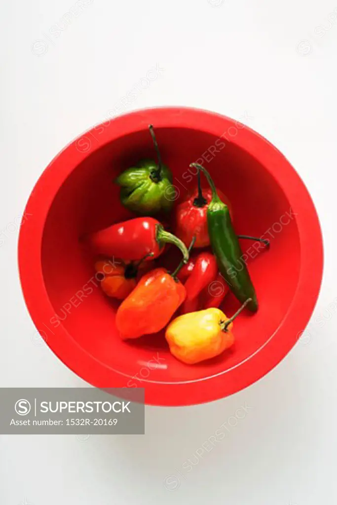 Various chili peppers in red bowl