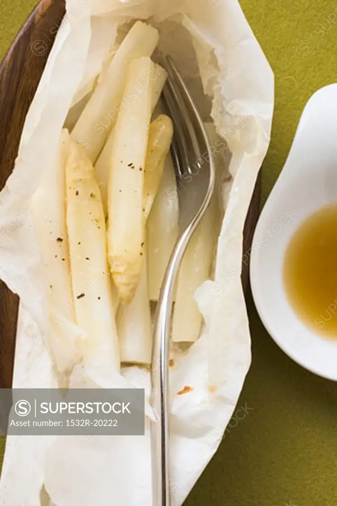 White asparagus cooked in foil, with fork