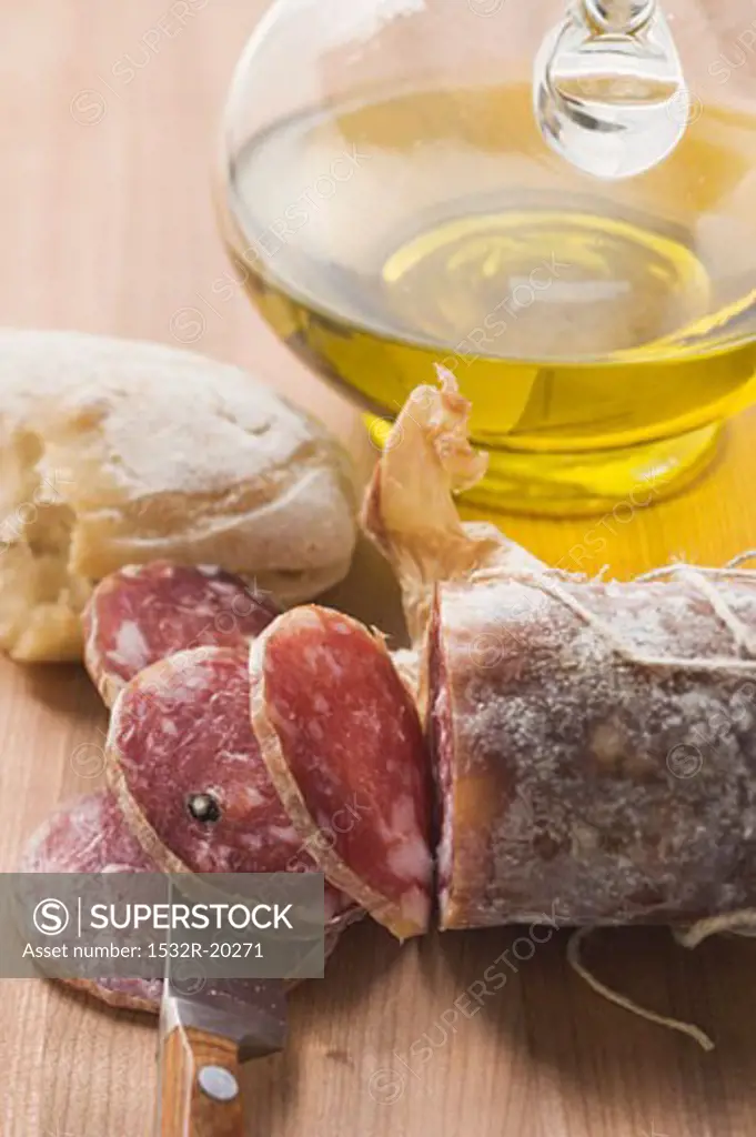 Italian salami, partly sliced, white bread, olive oil