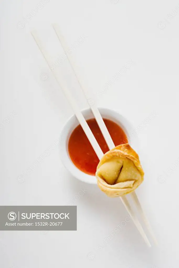 One deep-fried wonton with sweet and sour sauce